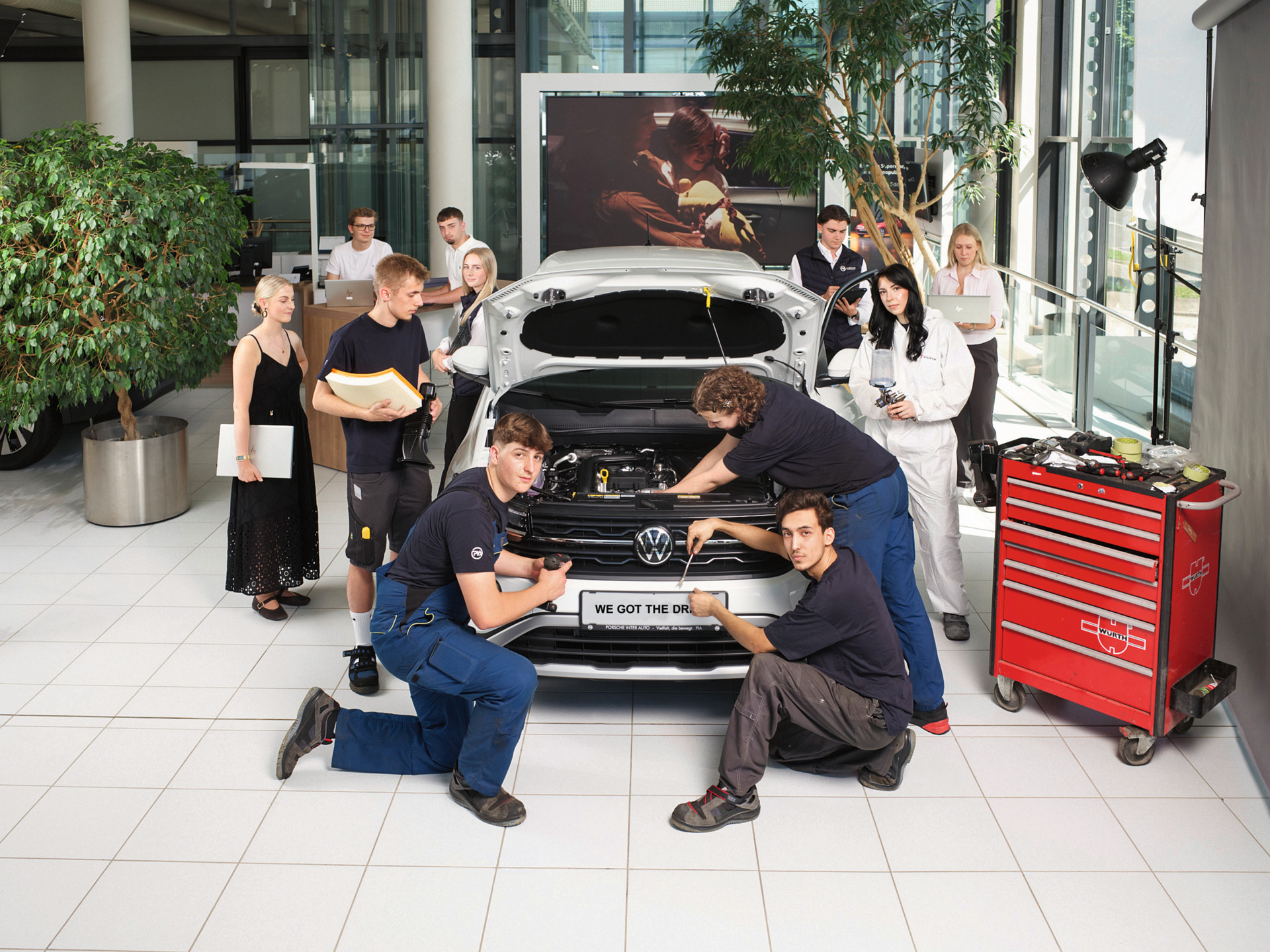 Automechaniker-Lehrlinge bei der Arbeit an einem VW in einer Werkstatt in Österreich