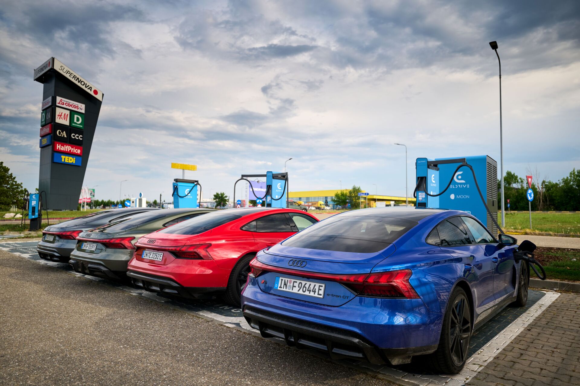 Elektroautos laden an Ladesäulen in einem Einkaufszentrum bei Schönwetter.